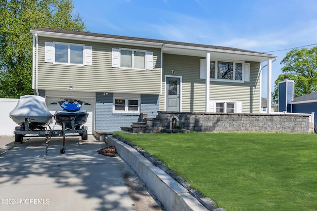 rear view of property with a lawn and a garage