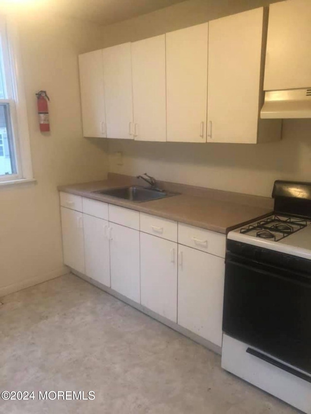 kitchen featuring sink, white cabinetry, white gas range oven, and exhaust hood