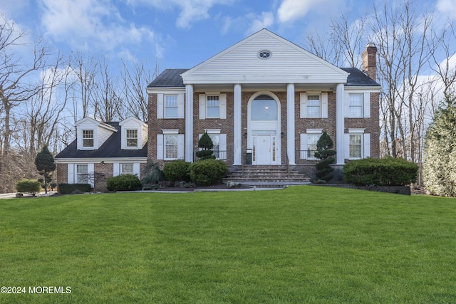 greek revival inspired property with a front yard