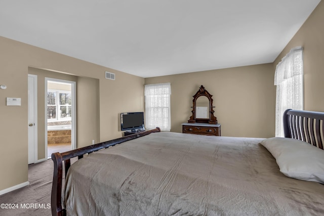 bedroom with light carpet and connected bathroom