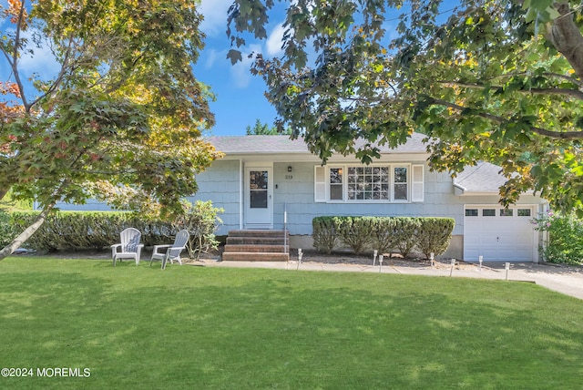 view of front of property featuring a garage and a front lawn