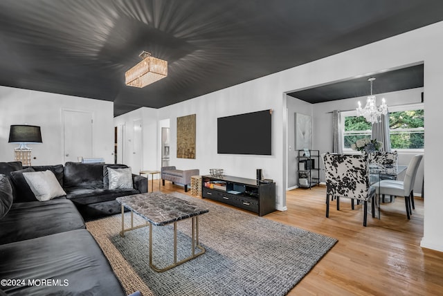 living room featuring wood-type flooring and a notable chandelier