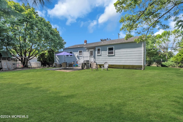 back of property with a lawn and a patio area