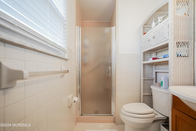 bathroom with tile patterned flooring, toilet, a shower with door, tile walls, and vanity