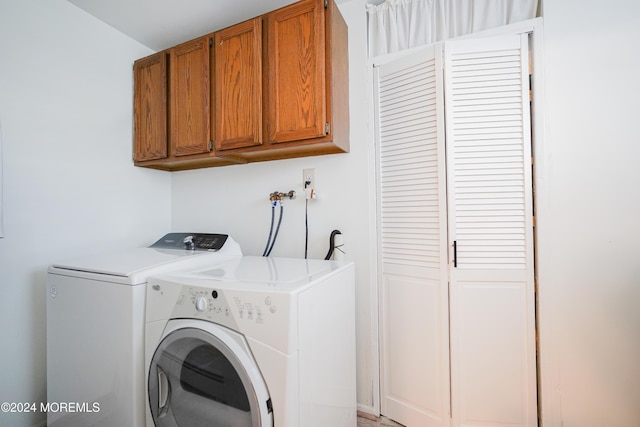 clothes washing area with cabinets and separate washer and dryer