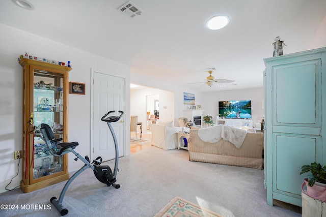 workout room with light colored carpet and ceiling fan