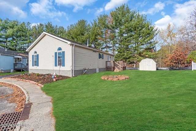 view of side of property with a lawn, a wooden deck, and a storage shed