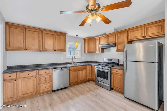 kitchen featuring appliances with stainless steel finishes, light hardwood / wood-style flooring, ceiling fan, and sink