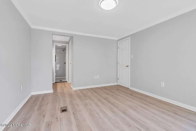 unfurnished room with ornamental molding and light wood-type flooring