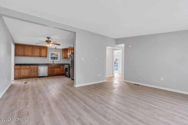 unfurnished living room featuring ceiling fan, sink, and light hardwood / wood-style floors