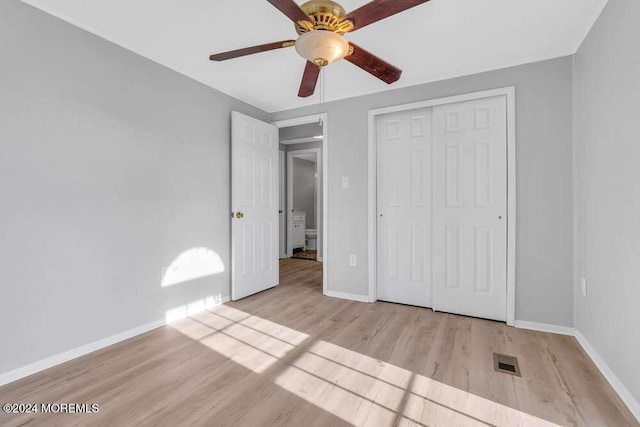 unfurnished bedroom featuring ceiling fan, a closet, and light wood-type flooring