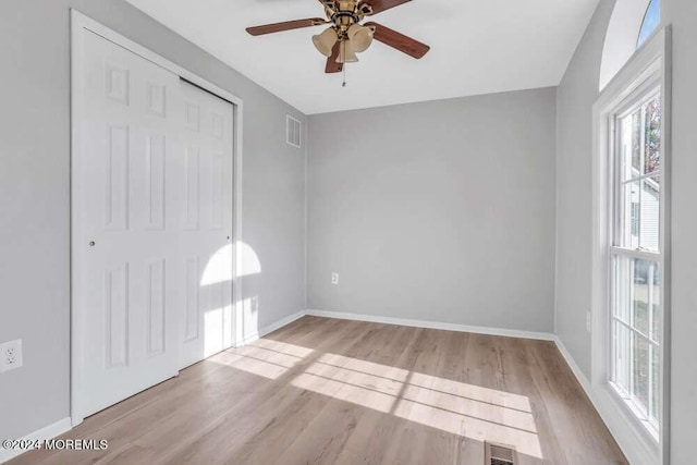 unfurnished bedroom with ceiling fan, a closet, and light hardwood / wood-style floors