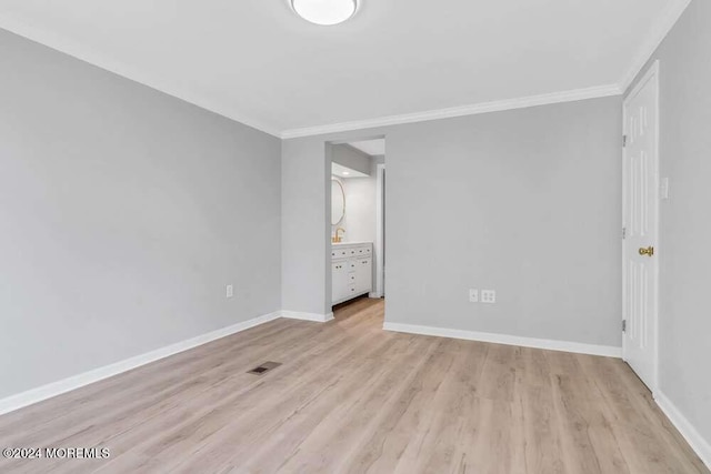 empty room featuring light hardwood / wood-style flooring and crown molding