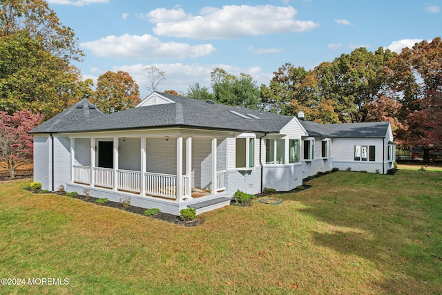 rear view of house with a porch and a lawn