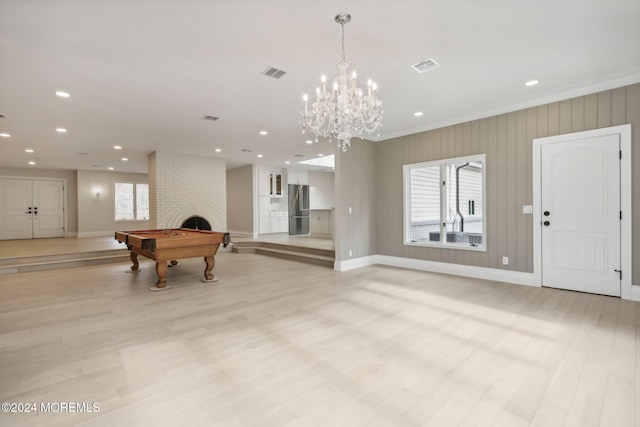 rec room with light hardwood / wood-style floors, ornamental molding, billiards, and a brick fireplace