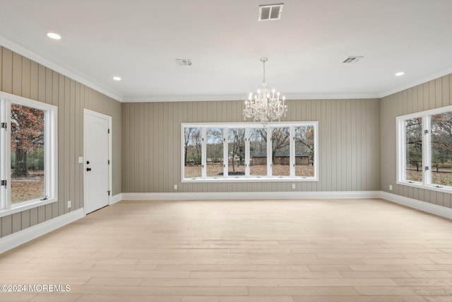 interior space featuring ornamental molding, light hardwood / wood-style floors, plenty of natural light, and a notable chandelier