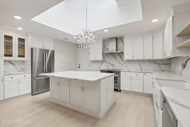 kitchen with wall chimney exhaust hood, premium appliances, a center island, and tasteful backsplash