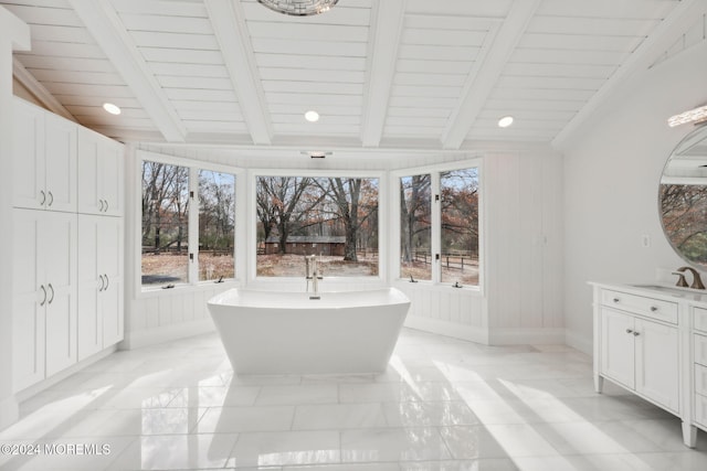 bathroom with vaulted ceiling with beams, a tub to relax in, plenty of natural light, and wood ceiling