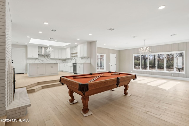 game room featuring a skylight, sink, billiards, a chandelier, and light hardwood / wood-style floors