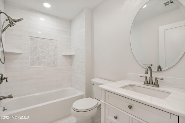 full bathroom featuring vanity, tiled shower / bath combo, and toilet