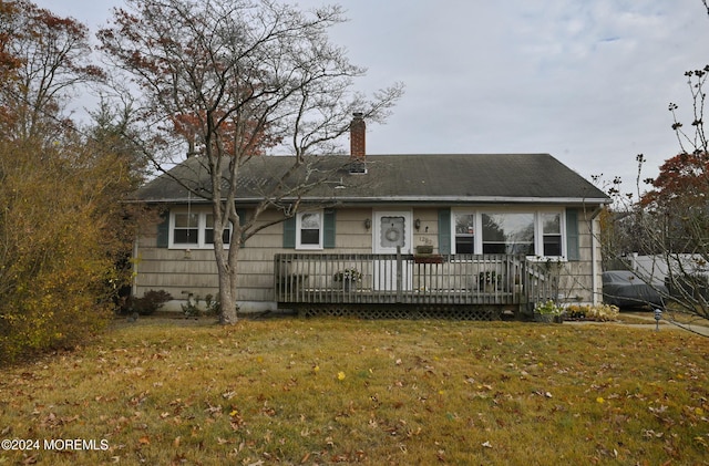 ranch-style home featuring a wooden deck and a front lawn