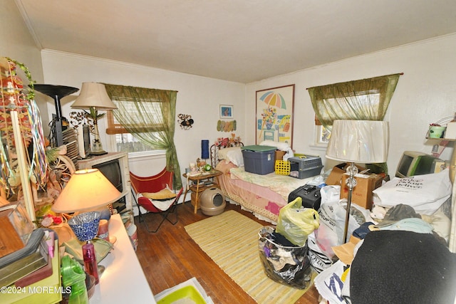 bedroom featuring crown molding and dark wood-type flooring