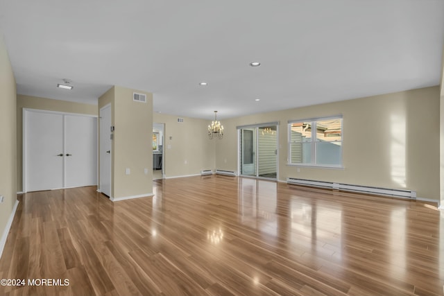 unfurnished living room with an inviting chandelier, hardwood / wood-style floors, and baseboard heating