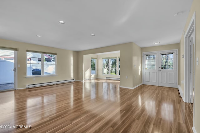 entryway with a baseboard radiator, plenty of natural light, and light hardwood / wood-style floors