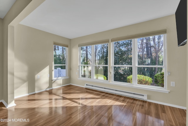 unfurnished room featuring light hardwood / wood-style flooring and a baseboard radiator