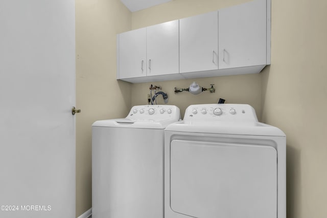 laundry room featuring washing machine and dryer and cabinets