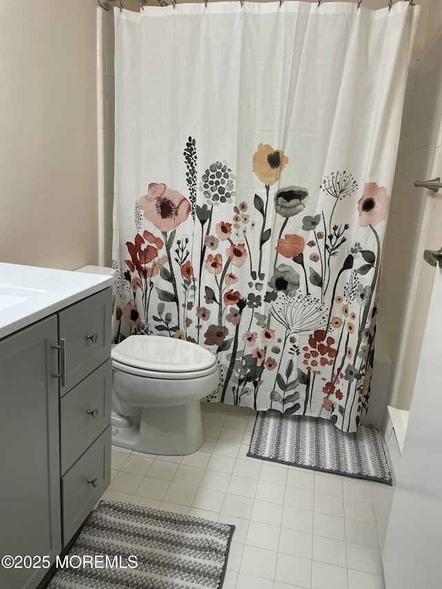 bathroom featuring vanity, curtained shower, tile patterned floors, and toilet