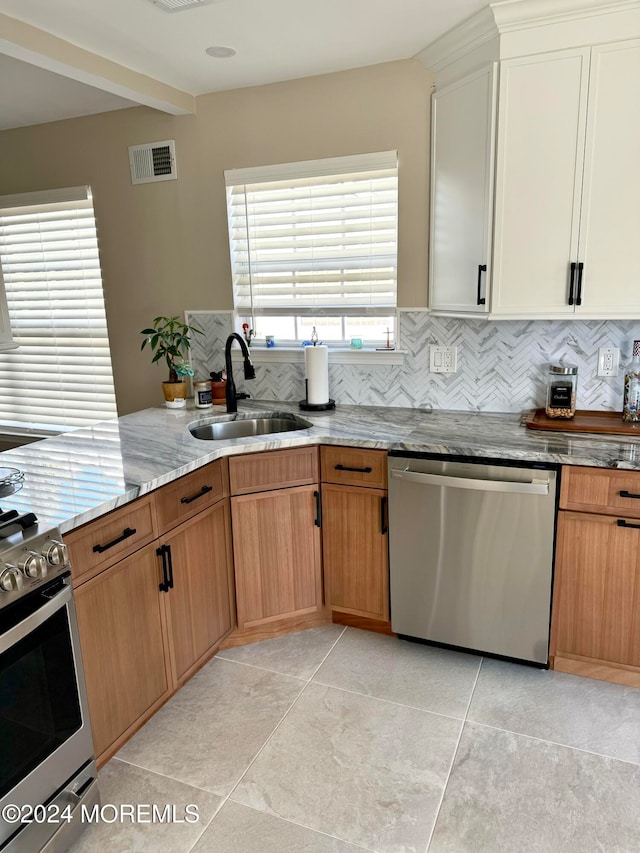 kitchen featuring tasteful backsplash, sink, white cabinets, and stainless steel appliances