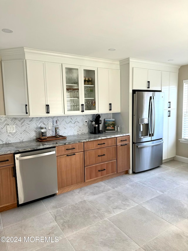 kitchen with white cabinets, appliances with stainless steel finishes, backsplash, and light tile patterned floors