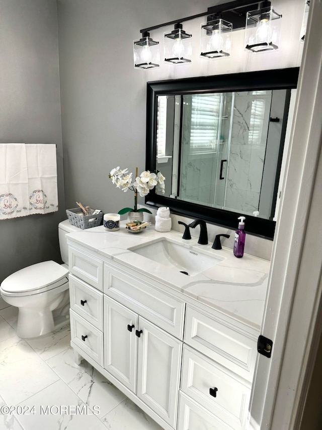 bathroom with vanity, toilet, and a shower with door