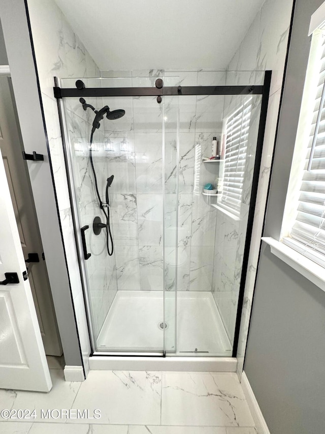 bathroom with a shower with door