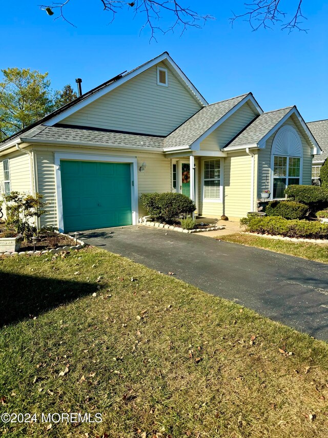 single story home featuring a front yard and a garage