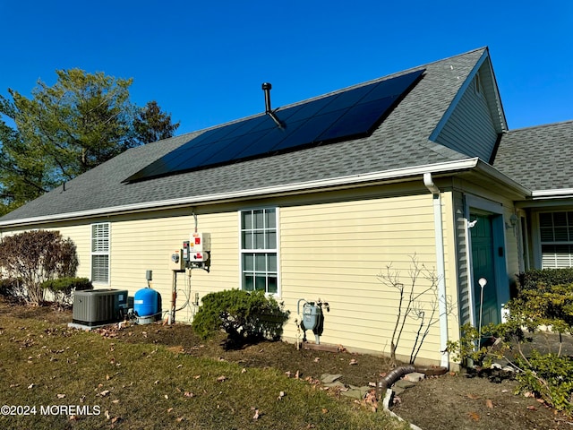 view of property exterior featuring cooling unit and solar panels