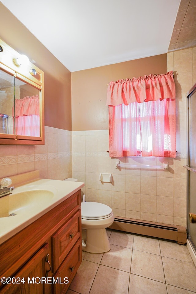 bathroom featuring vanity, a baseboard heating unit, tile patterned floors, toilet, and tile walls