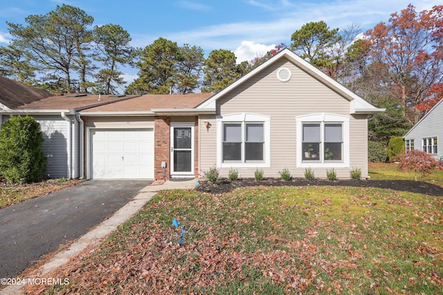 ranch-style home featuring a front lawn and a garage