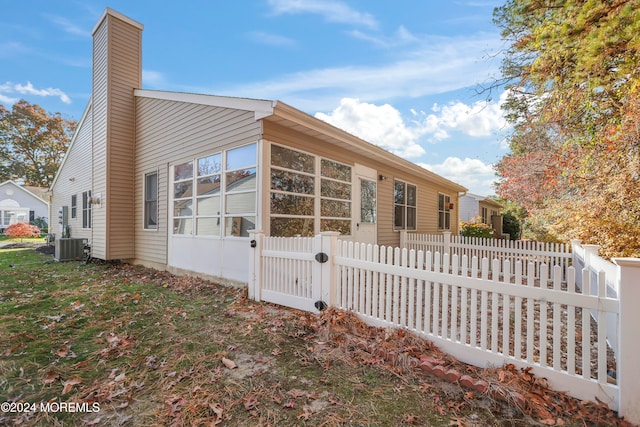 view of home's exterior featuring a sunroom and central AC unit