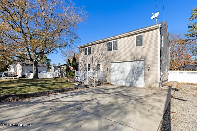 back of property with a garage and a yard