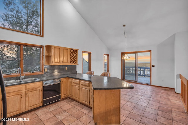 kitchen featuring sink, black dishwasher, tasteful backsplash, high vaulted ceiling, and kitchen peninsula