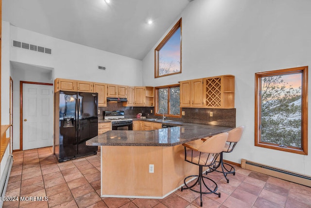 kitchen with high vaulted ceiling, white range with gas cooktop, kitchen peninsula, and black refrigerator with ice dispenser