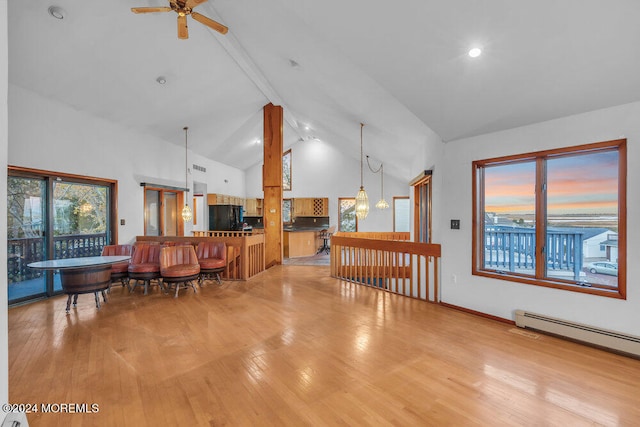 living room with high vaulted ceiling, a baseboard heating unit, ceiling fan, beamed ceiling, and light hardwood / wood-style floors