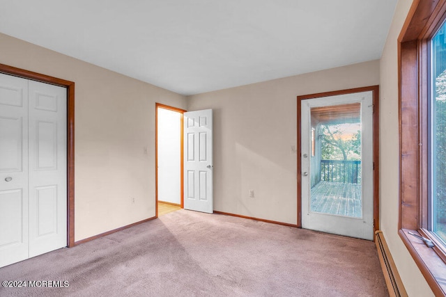 unfurnished bedroom featuring a closet, light carpet, a baseboard radiator, and multiple windows