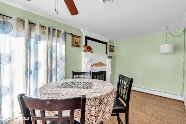 dining room with hardwood / wood-style flooring, ceiling fan, and a baseboard radiator