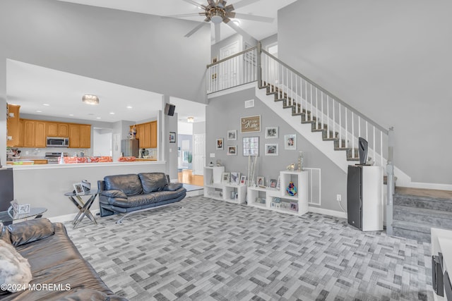 carpeted living room featuring a high ceiling and ceiling fan