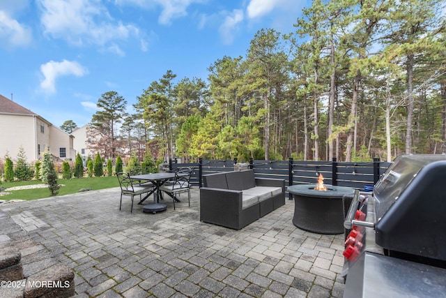 view of patio with area for grilling and an outdoor living space with a fire pit