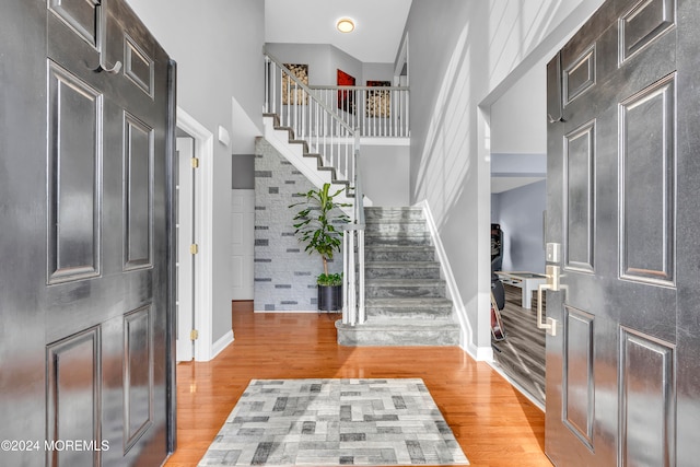 foyer featuring a towering ceiling and light wood-type flooring