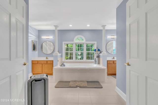 bathroom with ornate columns, tile patterned flooring, vanity, and a relaxing tiled tub